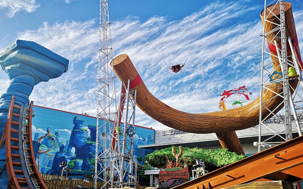 Sling shot ride at Angry Birds World Theme Park with large wooden structure and riders in the air.