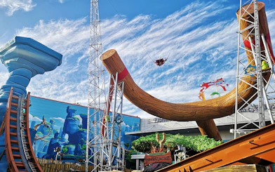 Sling shot ride at Angry Birds World Theme Park with large wooden structure and riders in the air.