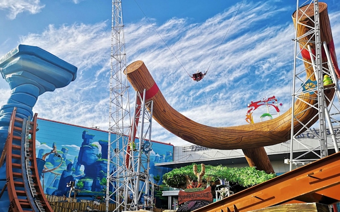 Sling shot ride at Angry Birds World Theme Park with large wooden structure and riders in the air.