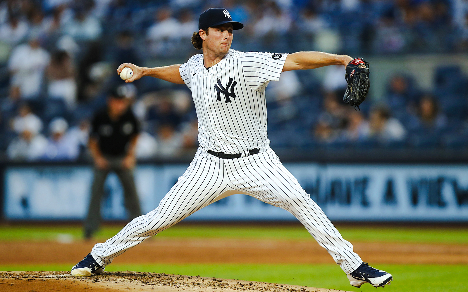 Pitcher in Yankees uniform throwing a baseball at Yankee Stadium.