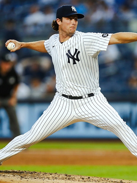 Pitcher in Yankees uniform throwing a baseball at Yankee Stadium.