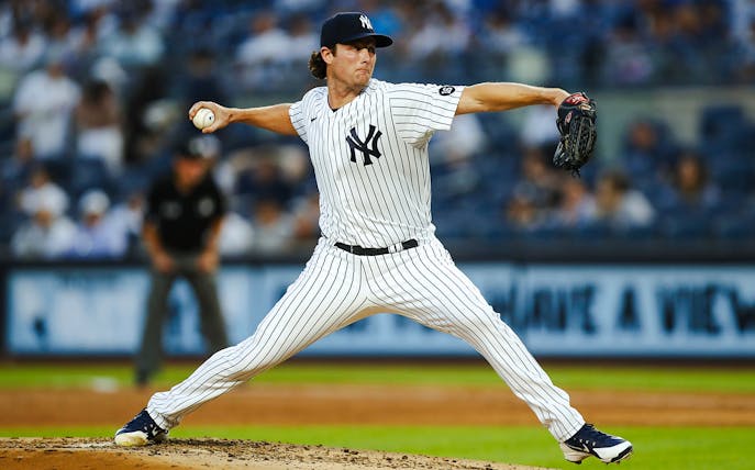 Pitcher in Yankees uniform throwing a baseball at Yankee Stadium.