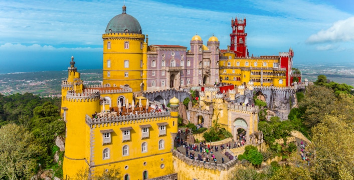 Pena Palace in Sintra, Portugal, with colorful towers and lush surroundings.