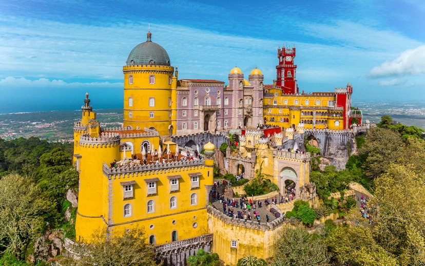 Pena Palace in Sintra, Portugal, with colorful towers and lush surroundings.