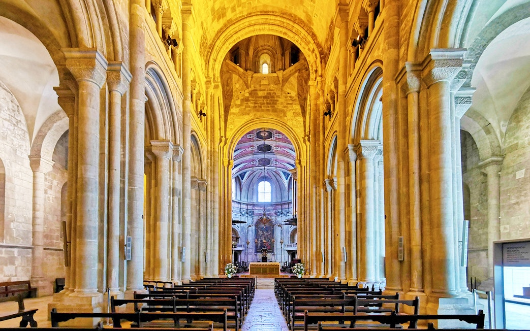 Se de Lisboa cathedral interior with stone arches and altar.