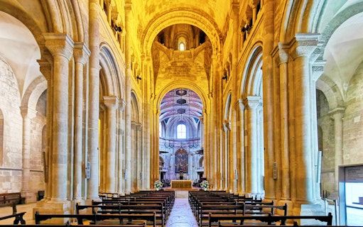 Se de Lisboa cathedral interior with stone arches and altar.