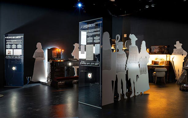 Exhibit at QUAKE: Lisbon Earthquake Museum with historical displays and silhouette figures.