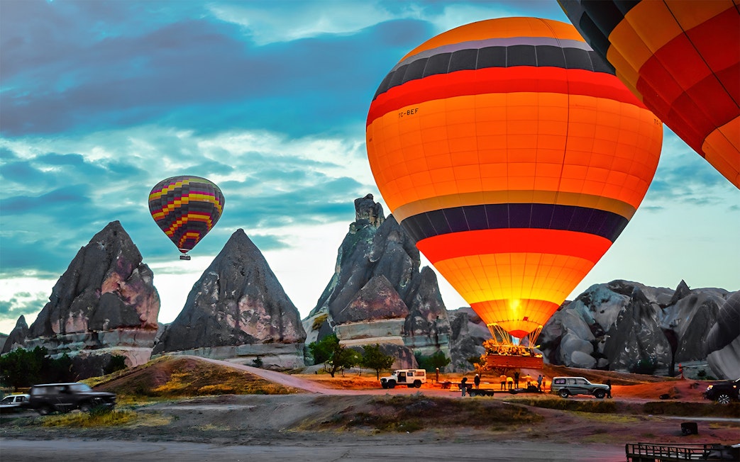 Hot air balloons over rock formations in Cappadocia, Turkey.
