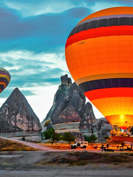 Hot air balloons over rock formations in Cappadocia, Turkey.