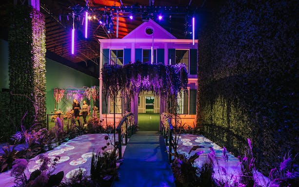 Entrance to Monet's Garden immersive exhibition in Vienna, featuring a bridge and projected water lilies.