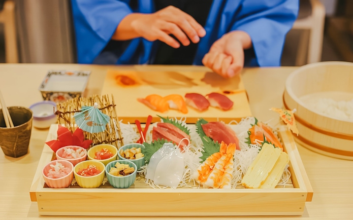 Tourist preparing sushi with assorted ingredients near Tokyo Tower.