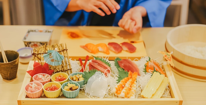 Tourist preparing sushi with assorted ingredients near Tokyo Tower.