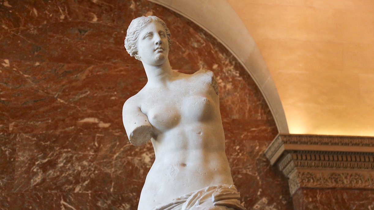 Tour group viewing artwork in Louvre Museum, Paris, during semi-private guided tour with skip-the-line access.
