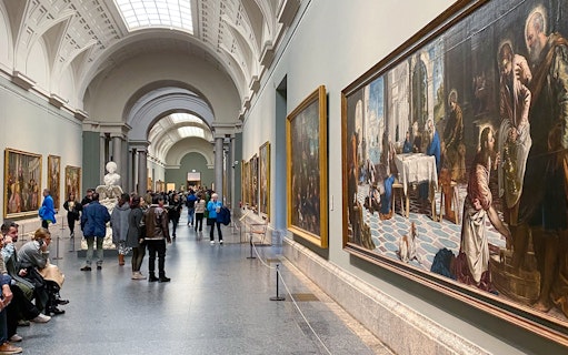 Visitors viewing paintings in a gallery at the Prado Museum, Madrid.