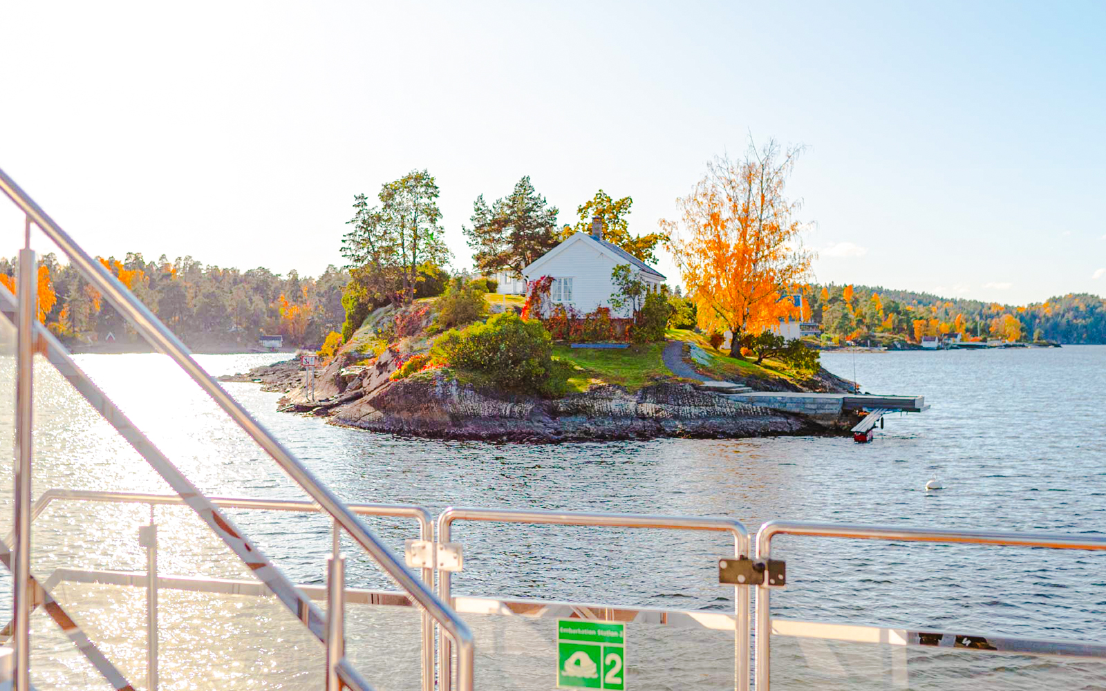 Fjord view from a boat with a small island and house near Oslo during a sightseeing cruise.