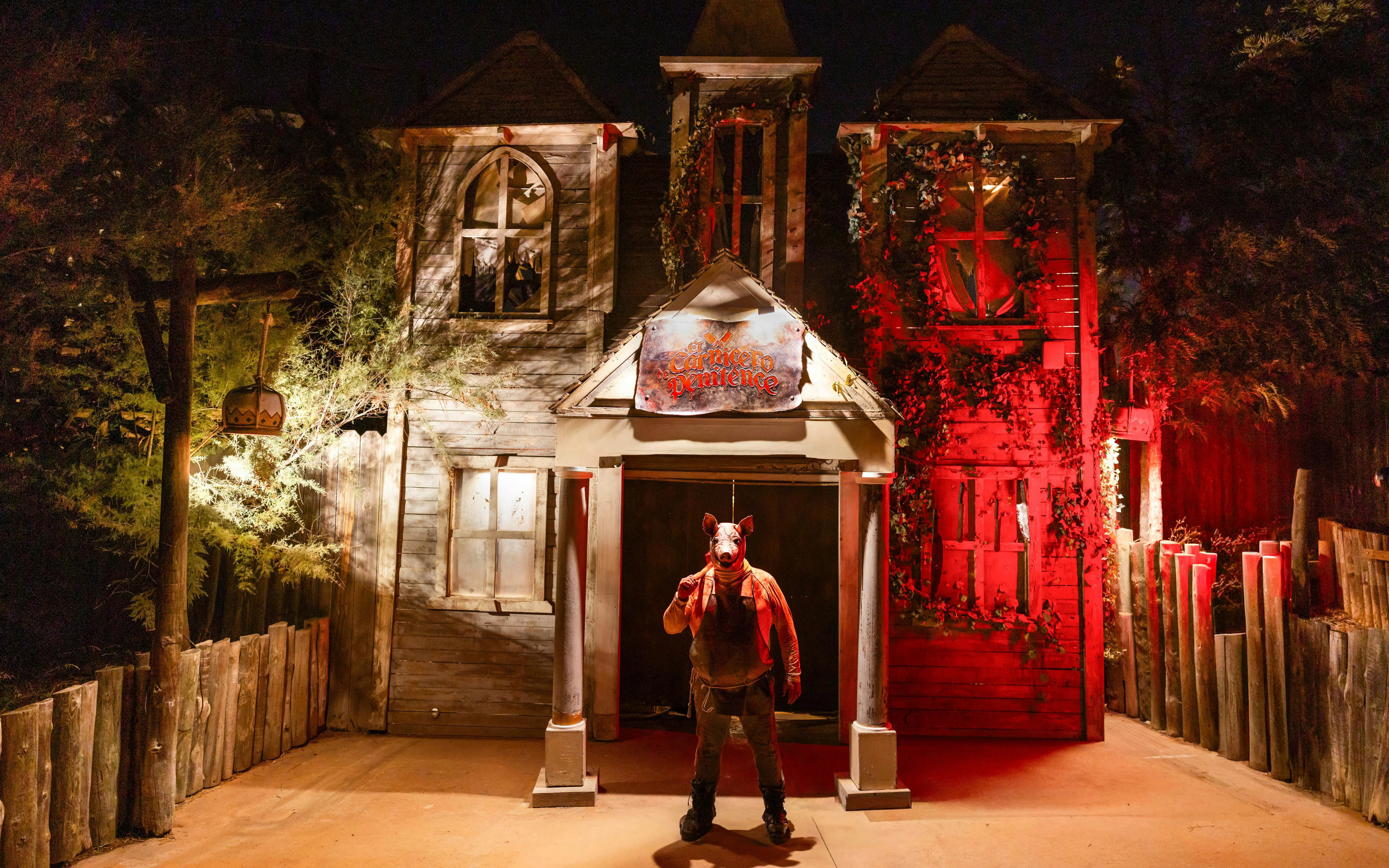 Haunted house facade with eerie lighting at PortAventura Park Halloween event.