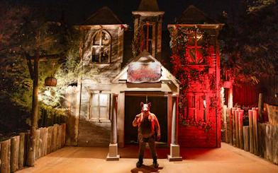 Haunted house facade with eerie lighting at PortAventura Park Halloween event.