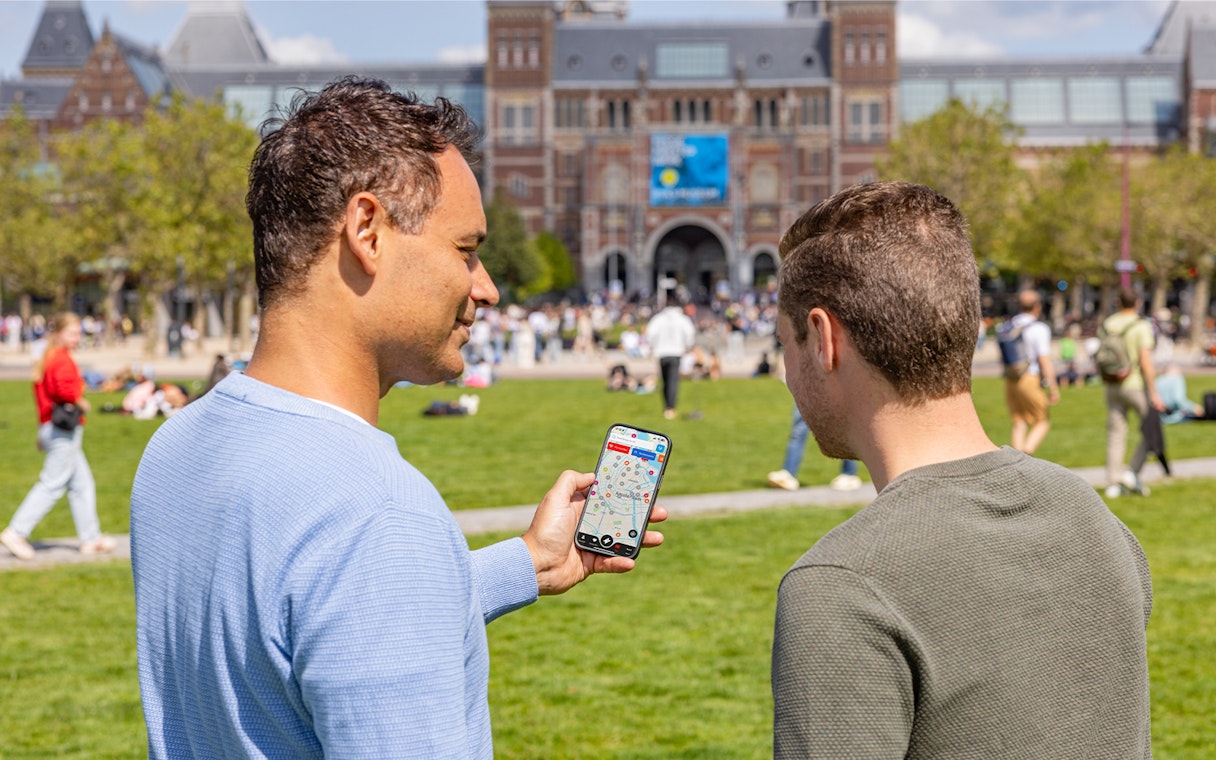 Tourists using I amsterdam City Card app in front of Rijksmuseum, Amsterdam.