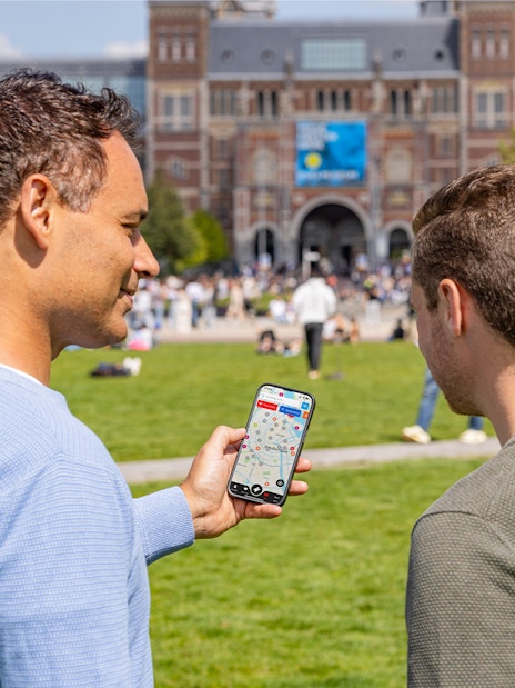 Tourists using I amsterdam City Card app in front of Rijksmuseum, Amsterdam.