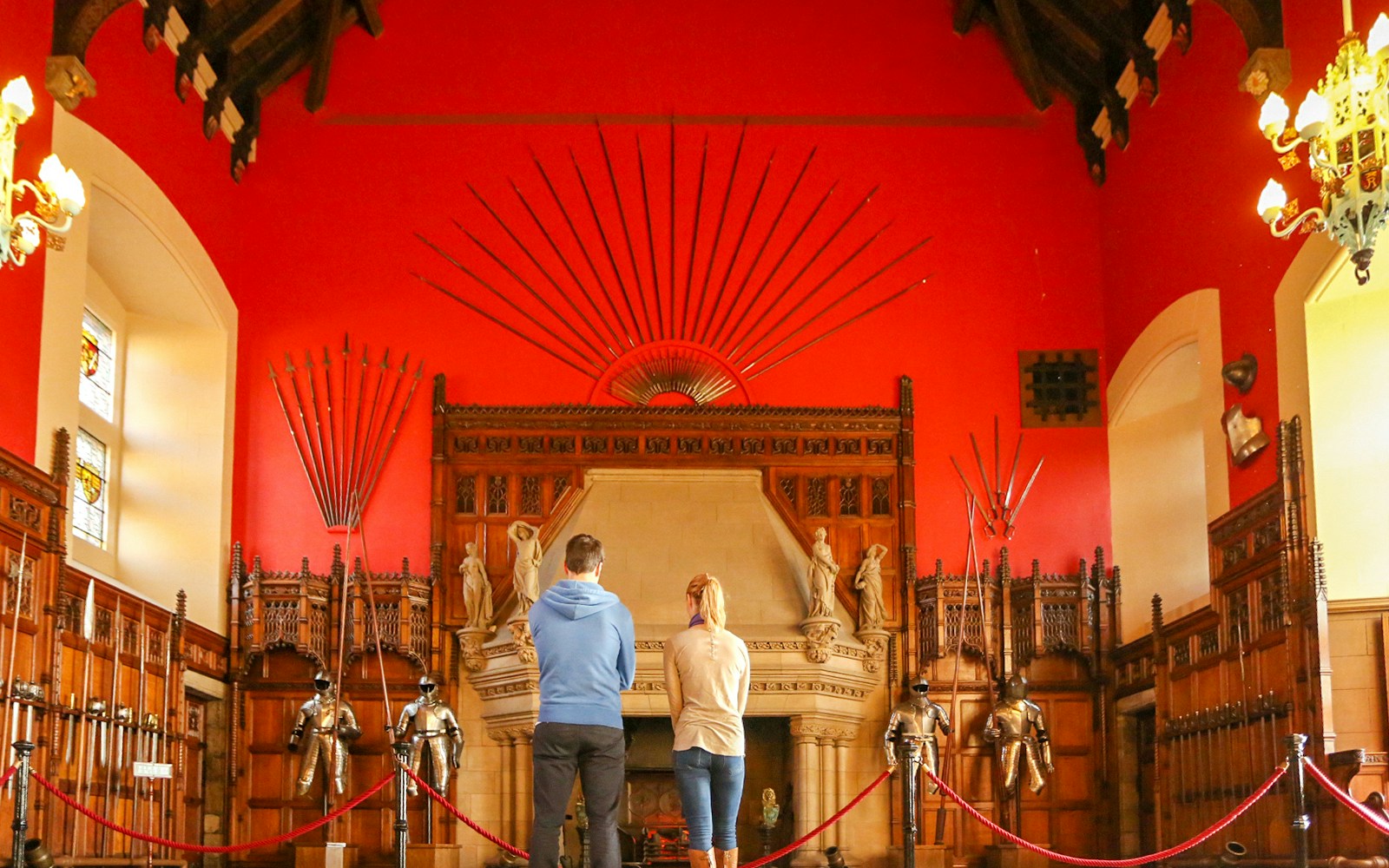 Visitors observing the Great Hall's medieval armor display inside Edinburgh Castle.