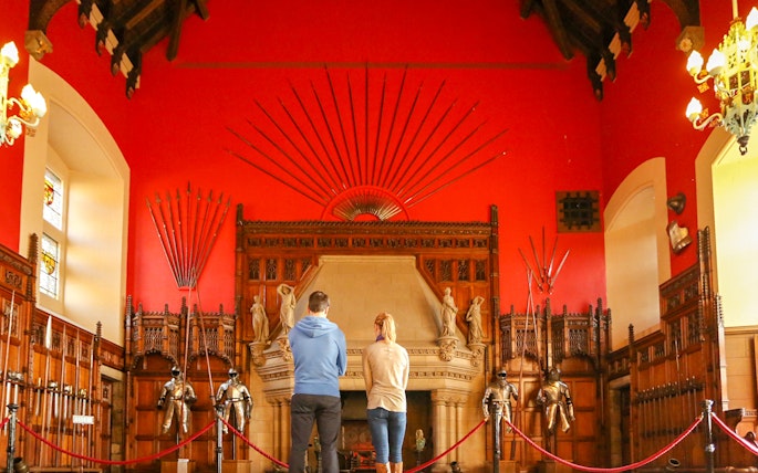 Visitors observing the Great Hall's medieval armor display inside Edinburgh Castle.