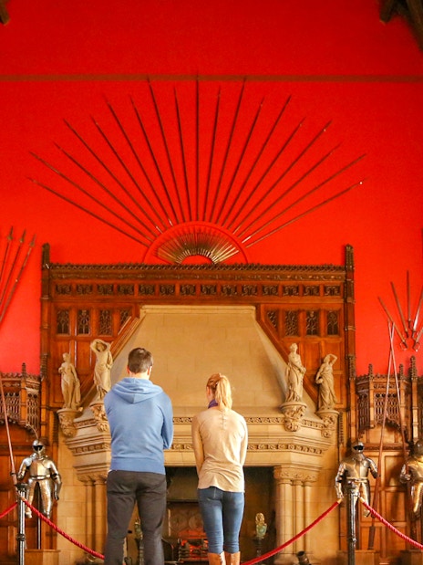 Visitors observing the Great Hall's medieval armor display inside Edinburgh Castle.