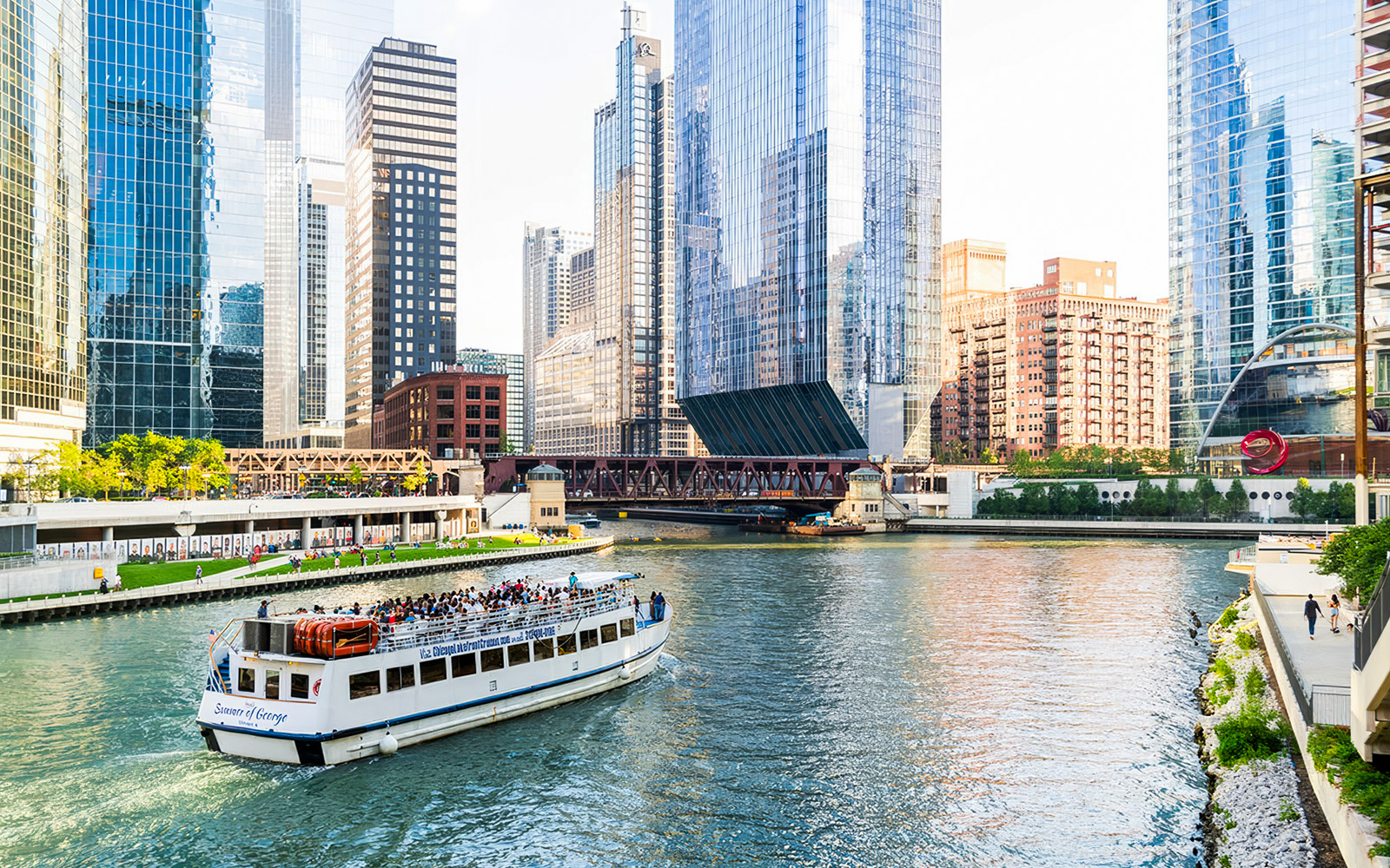 Chicago River cruise with tourists viewing downtown skyscrapers.