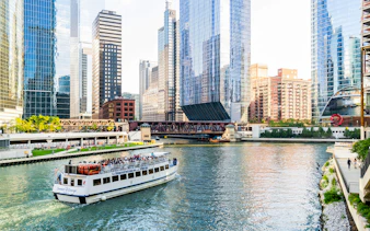 Chicago River cruise with tourists viewing downtown skyscrapers.