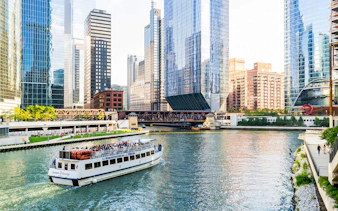 Chicago River cruise with tourists viewing downtown skyscrapers.