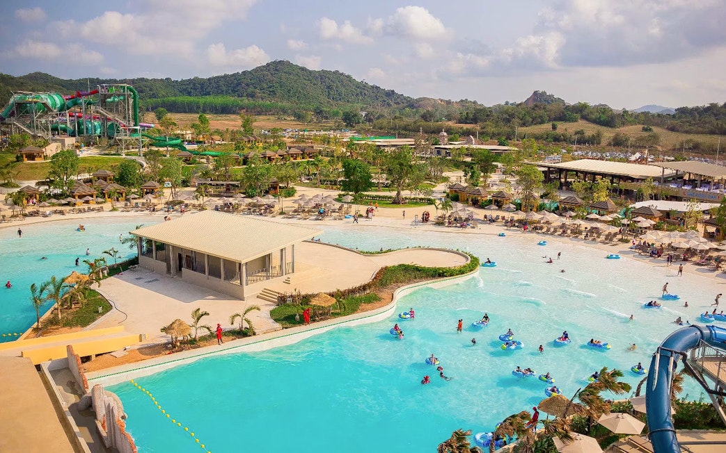 Visitors enjoying wave pool and slides at Ramayana Water Park, Thailand.