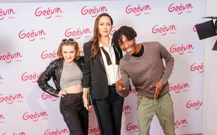 Visitors posing with a wax figure at Grévin Wax Museum, Paris.