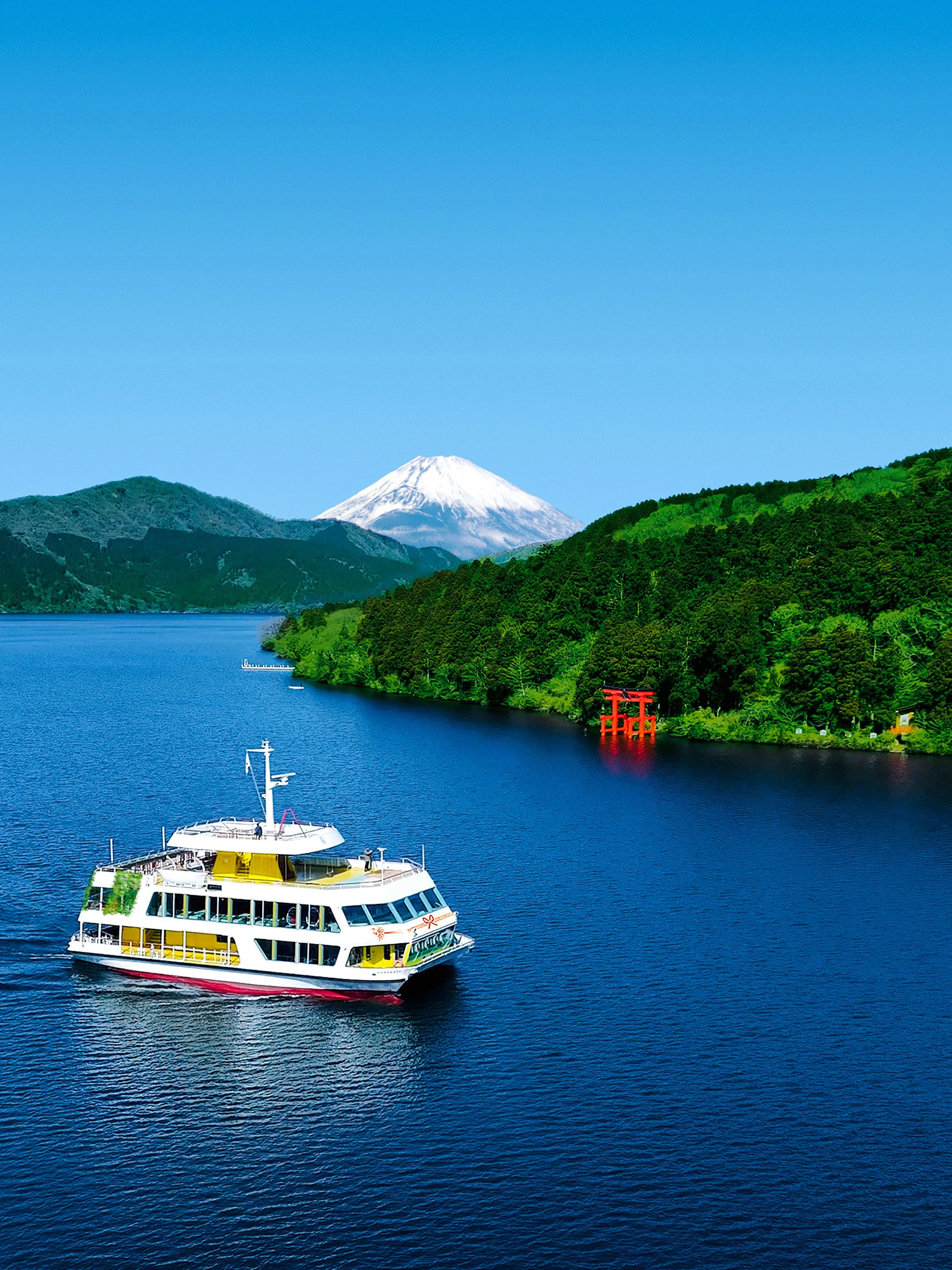 Hakone sightseeing cruise on Lake Ashi with Mount Fuji and torii gate in the background.