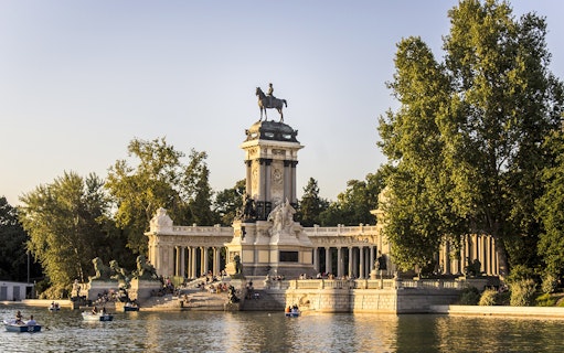 Monument to Alfonso XII with boats on the lake in El Retiro Park, Madrid.