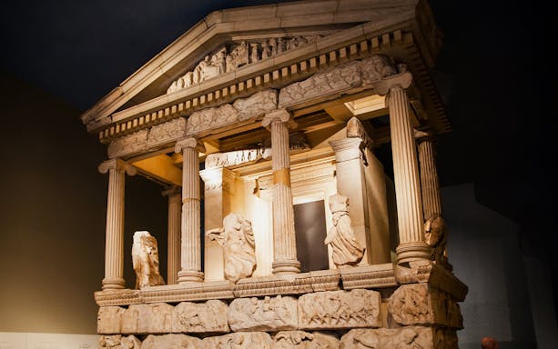 Ancient Greek temple facade at the British Museum with detailed sculptures and columns.