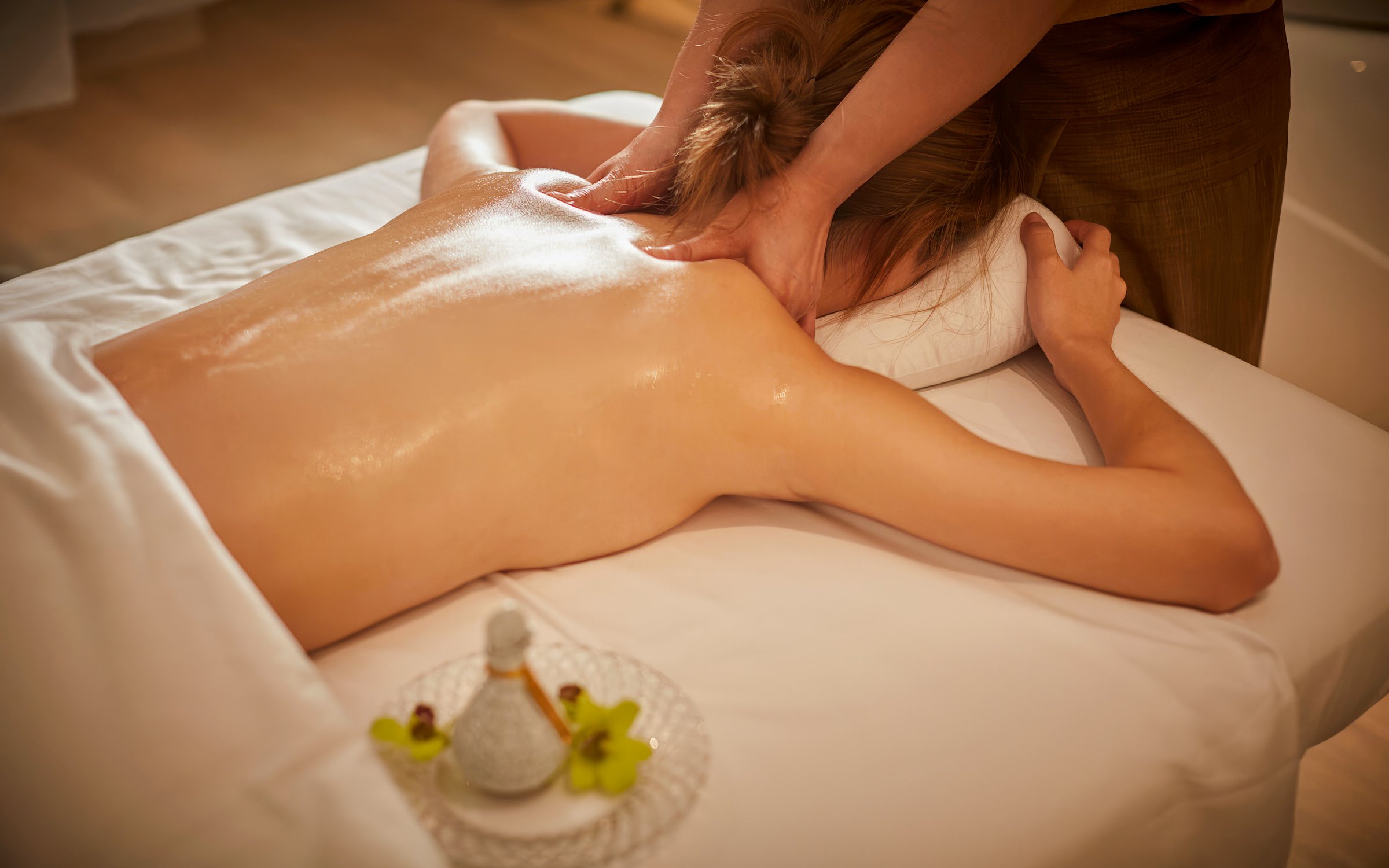 Person receiving a Diora Signature Body Scrub massage on a spa table.