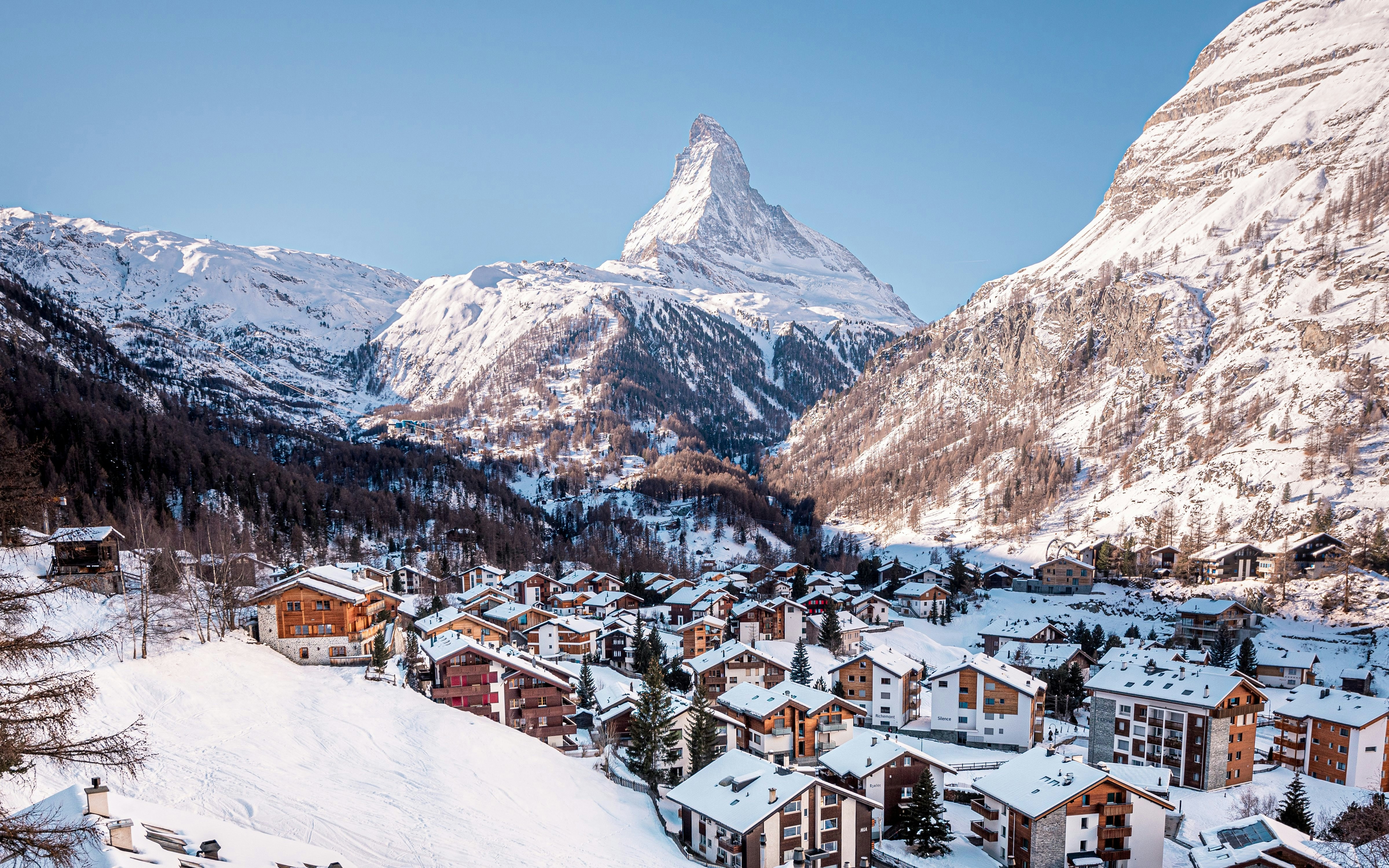 Snow-covered Matterhorn with Swiss village in foreground.