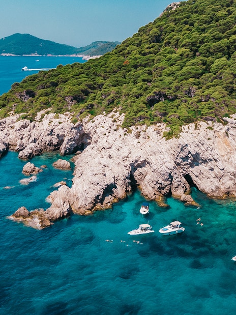 Private boats near rocky coastline and caves, Elaphiti Islands, Dubrovnik.