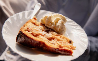 Apple pie with whipped cream on a plate, part of Eating Amsterdam: Food & Canals Tour.