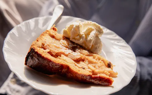 Apple pie with whipped cream on a plate, part of Eating Amsterdam: Food & Canals Tour.