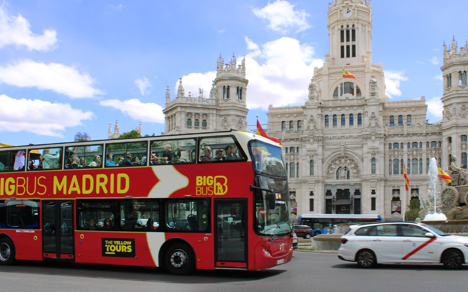 Open-top tour bus in front of Palacio de Cibeles, Madrid.