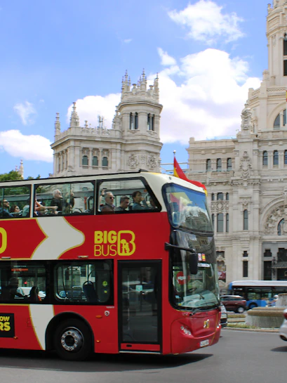 Open-top tour bus in front of Palacio de Cibeles, Madrid.