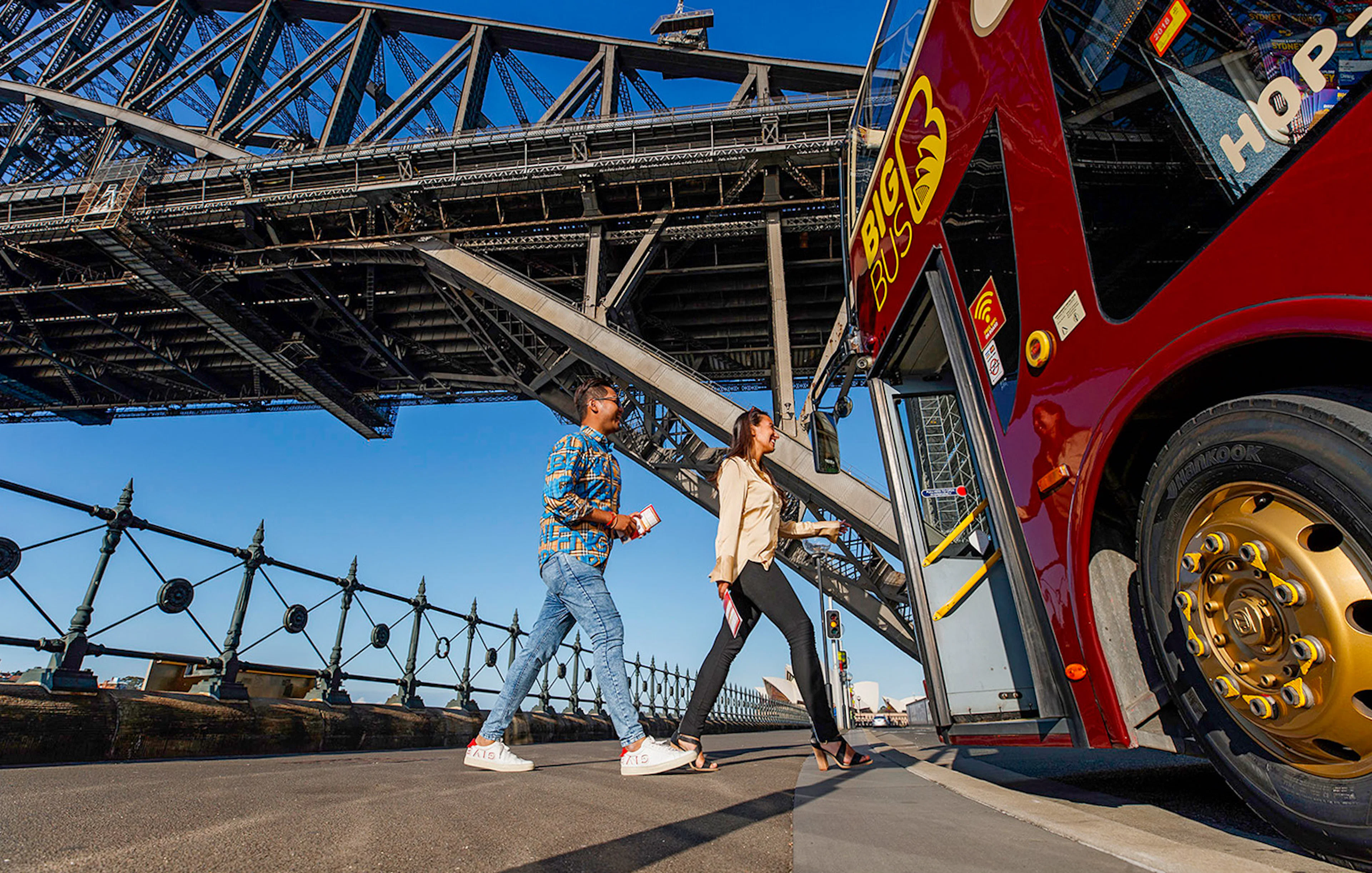 Visitors boarding Big Bus Sydney at Dawes Point with Sydney Harbour Bridge in the background.
