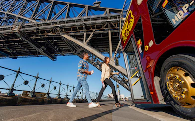 Visitors boarding Big Bus Sydney at Dawes Point with Sydney Harbour Bridge in the background.