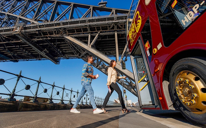Visitors boarding Big Bus Sydney at Dawes Point with Sydney Harbour Bridge in the background.
