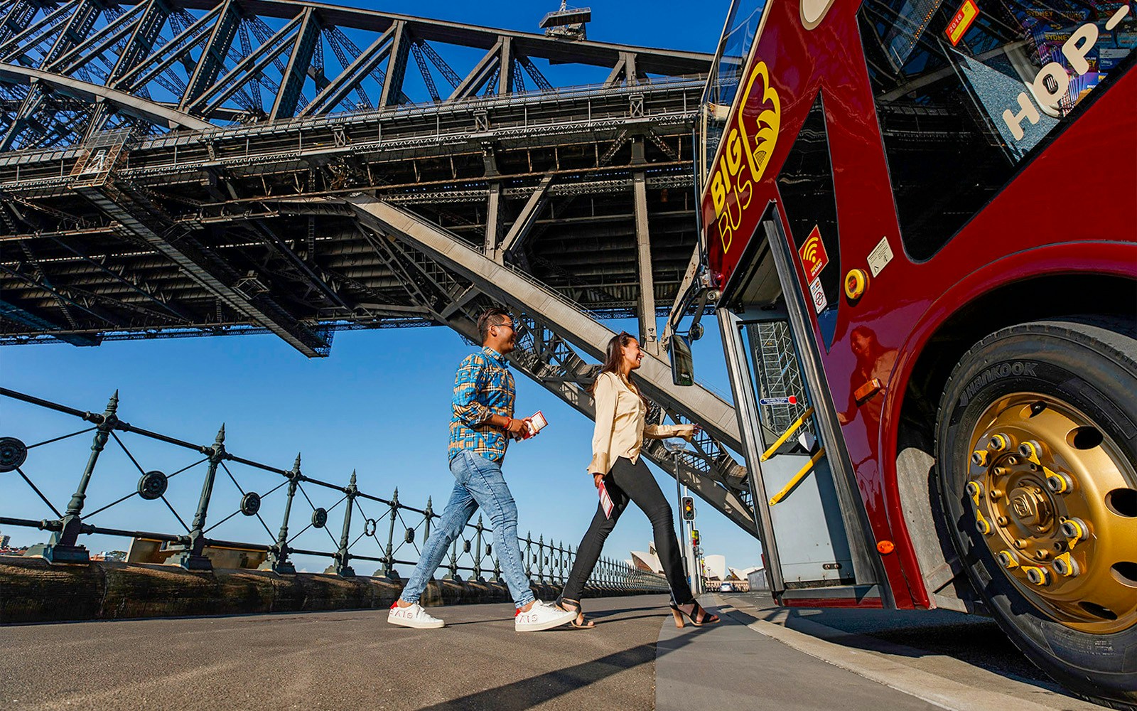 Visitors boarding Big Bus Sydney at Dawes Point with Sydney Harbour Bridge in the background.