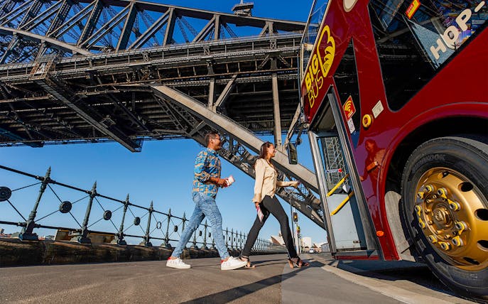 Visitors boarding Big Bus Sydney at Dawes Point with Sydney Harbour Bridge in the background.