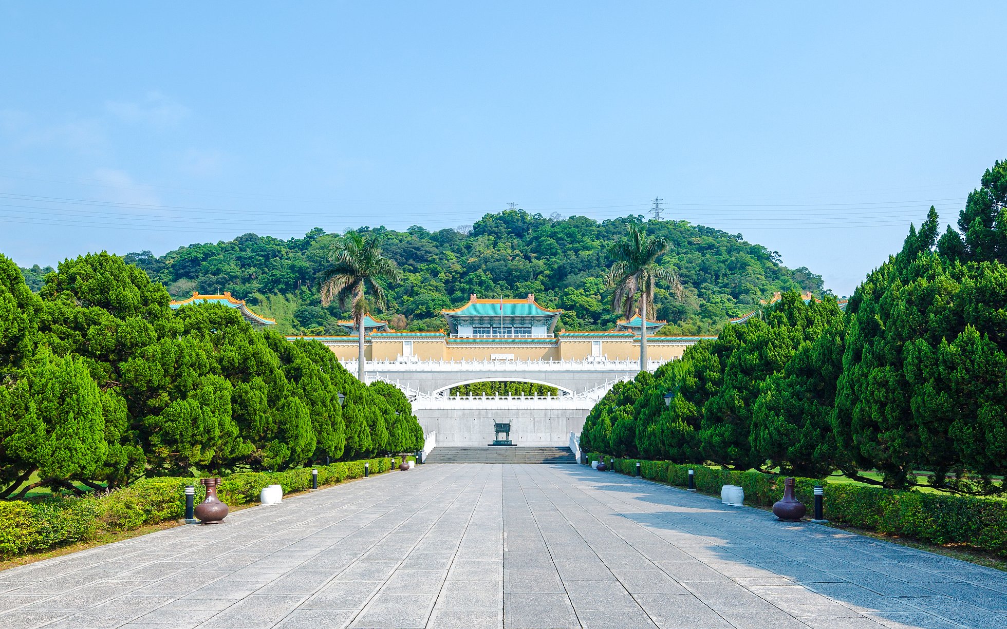 Taiwan Palace Museum entrance with lush greenery and distant hills.