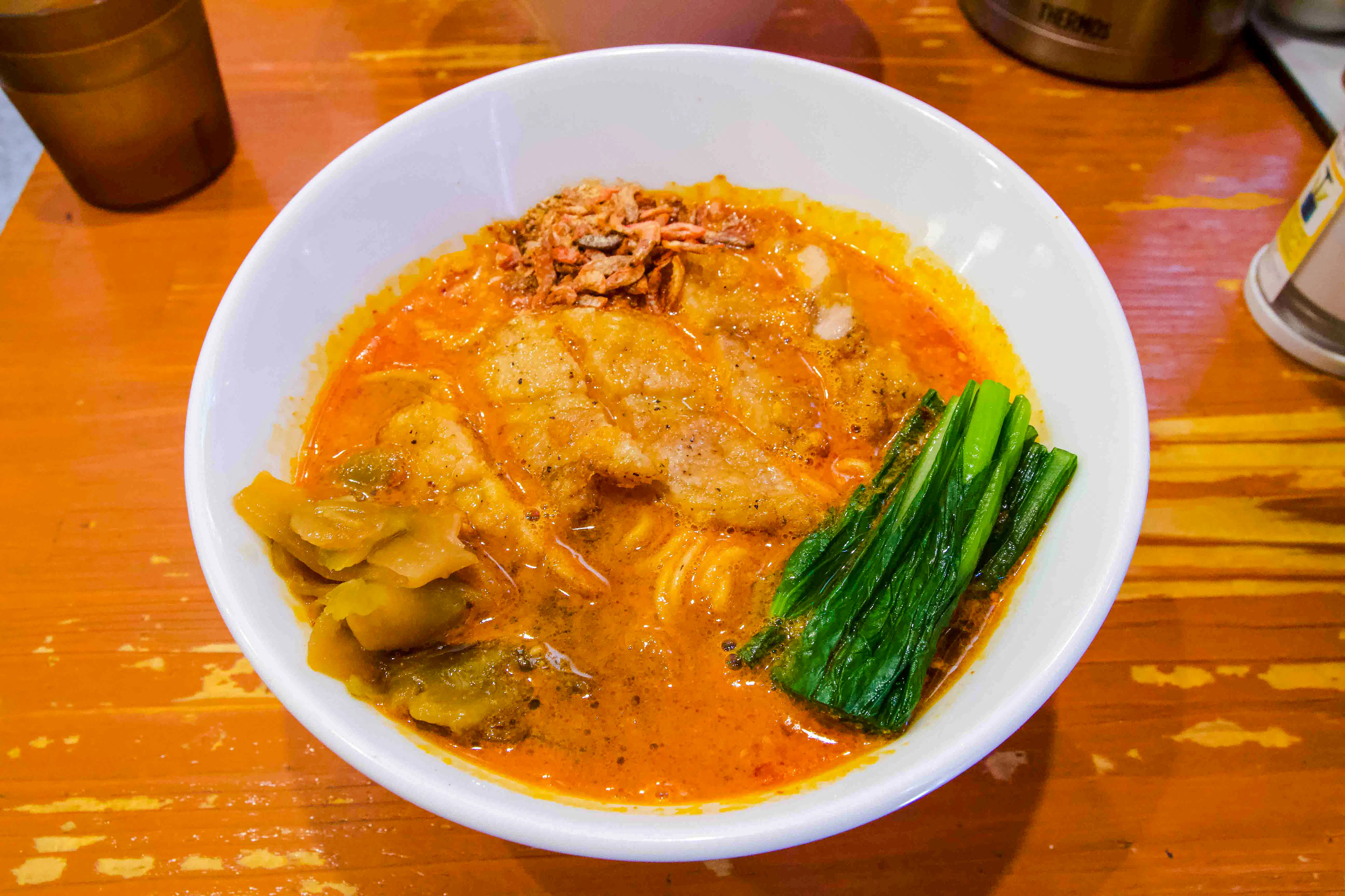 Spicy ramen bowl with greens and broth on Tokyo Spicy Ramen Tour.