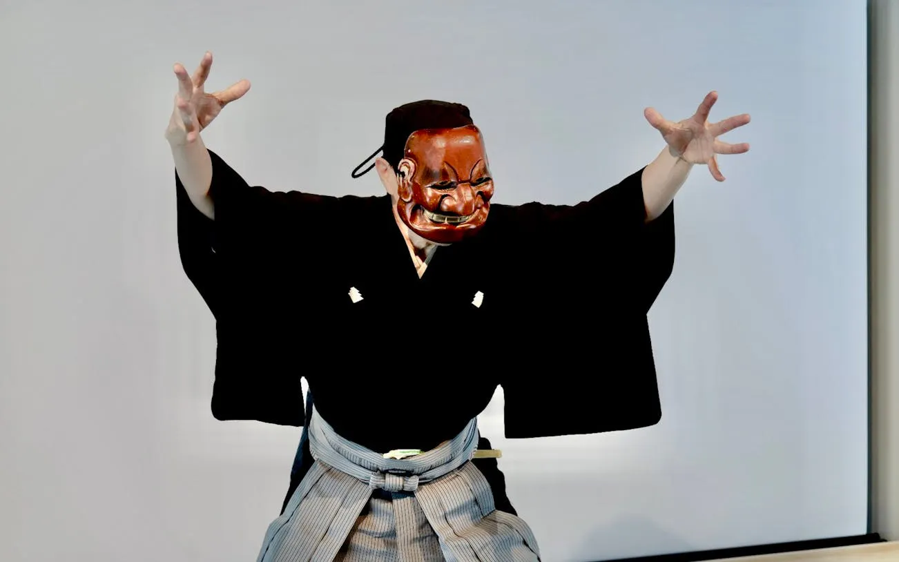 Noh performer in traditional mask and costume during Kyoto workshop.