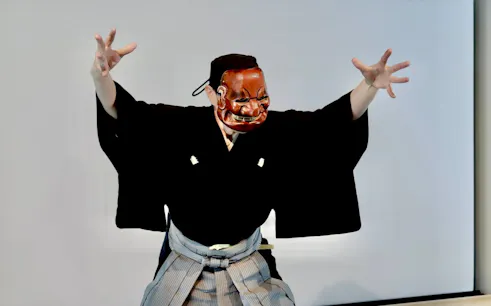 Noh performer in traditional mask and costume during Kyoto workshop.